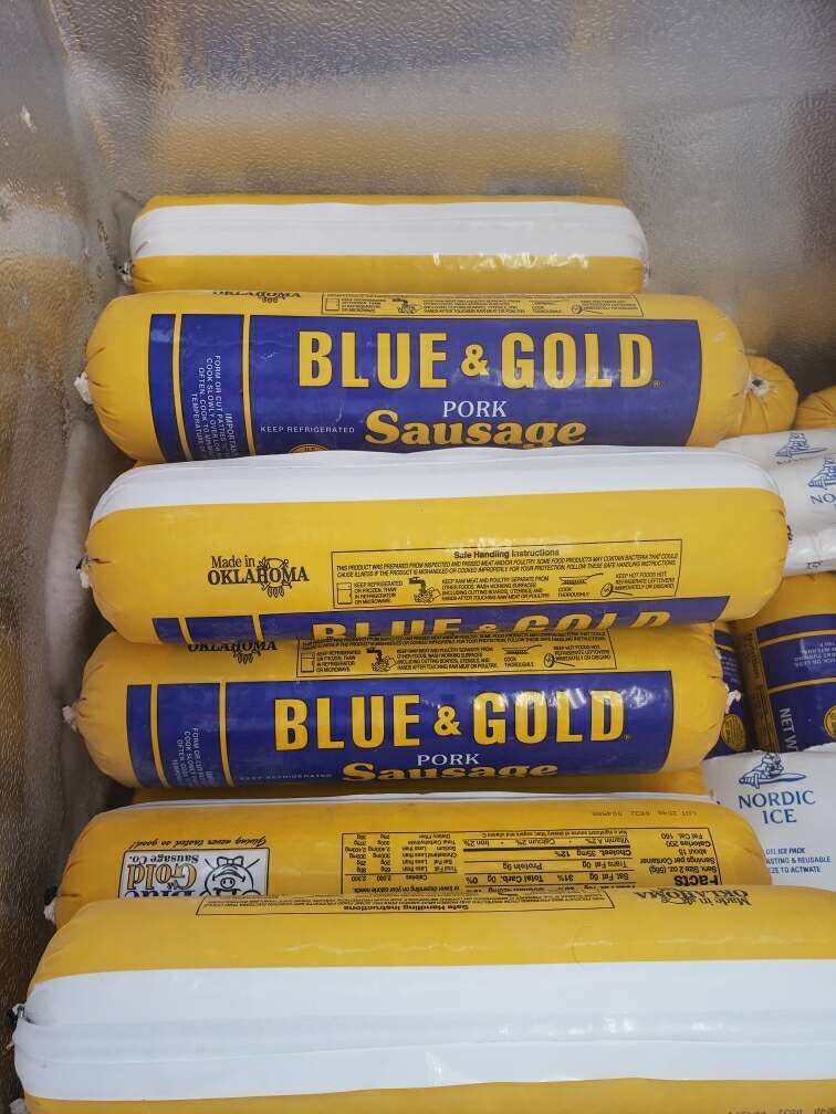 A stack of blue and gold pork sausages in a freezer
