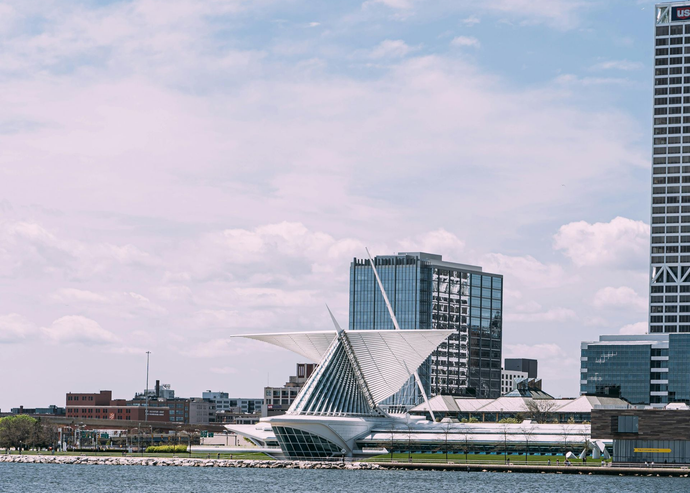 Milwaukee Art Museum with iconic wings against a blue sky, overlooking a lake.