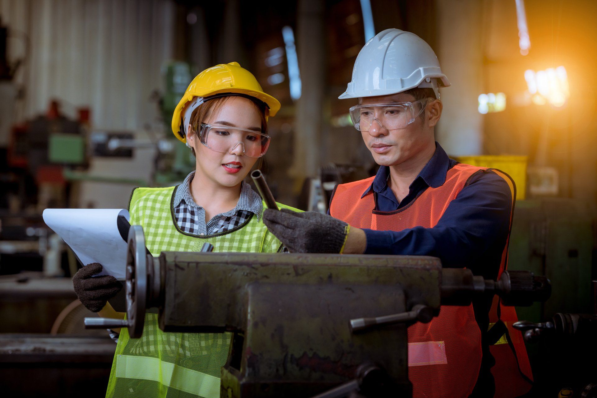 Un homme et une femme travaillent sur une machine dans une usine.