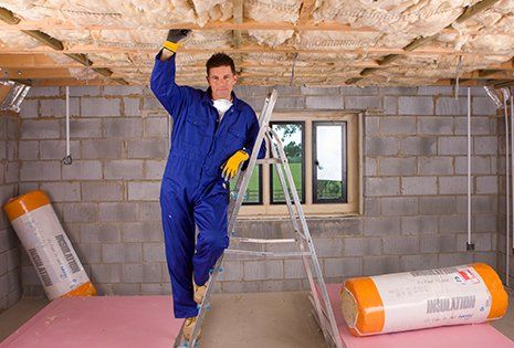 Worker Fitting Insulation into Roof — Environmental Insulation & Contracting, LLC