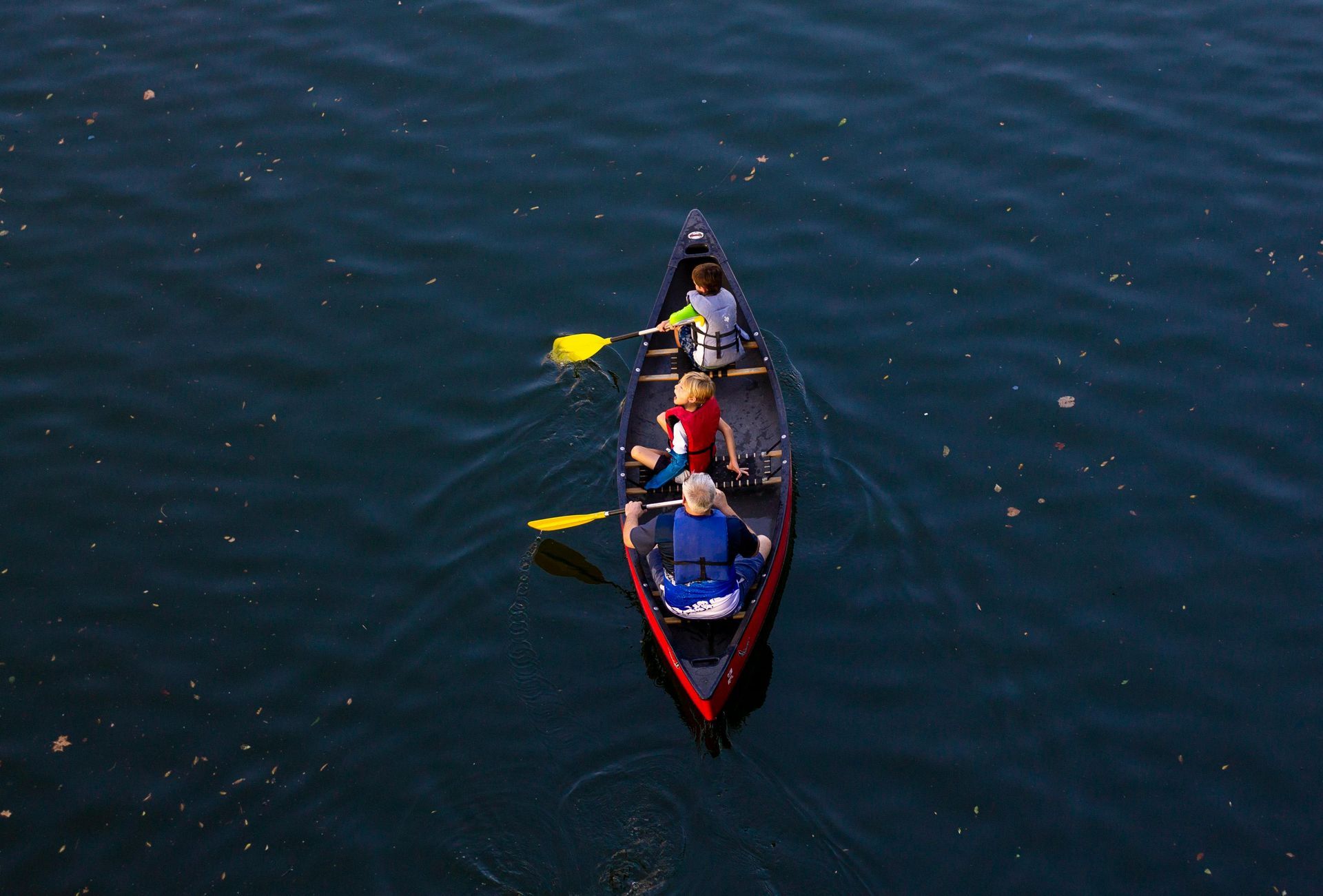 A group of people are paddling a canoe on a lake.