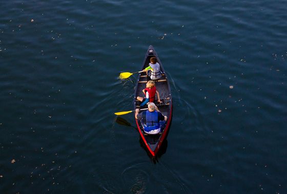 A group of people are paddling a canoe on a lake.