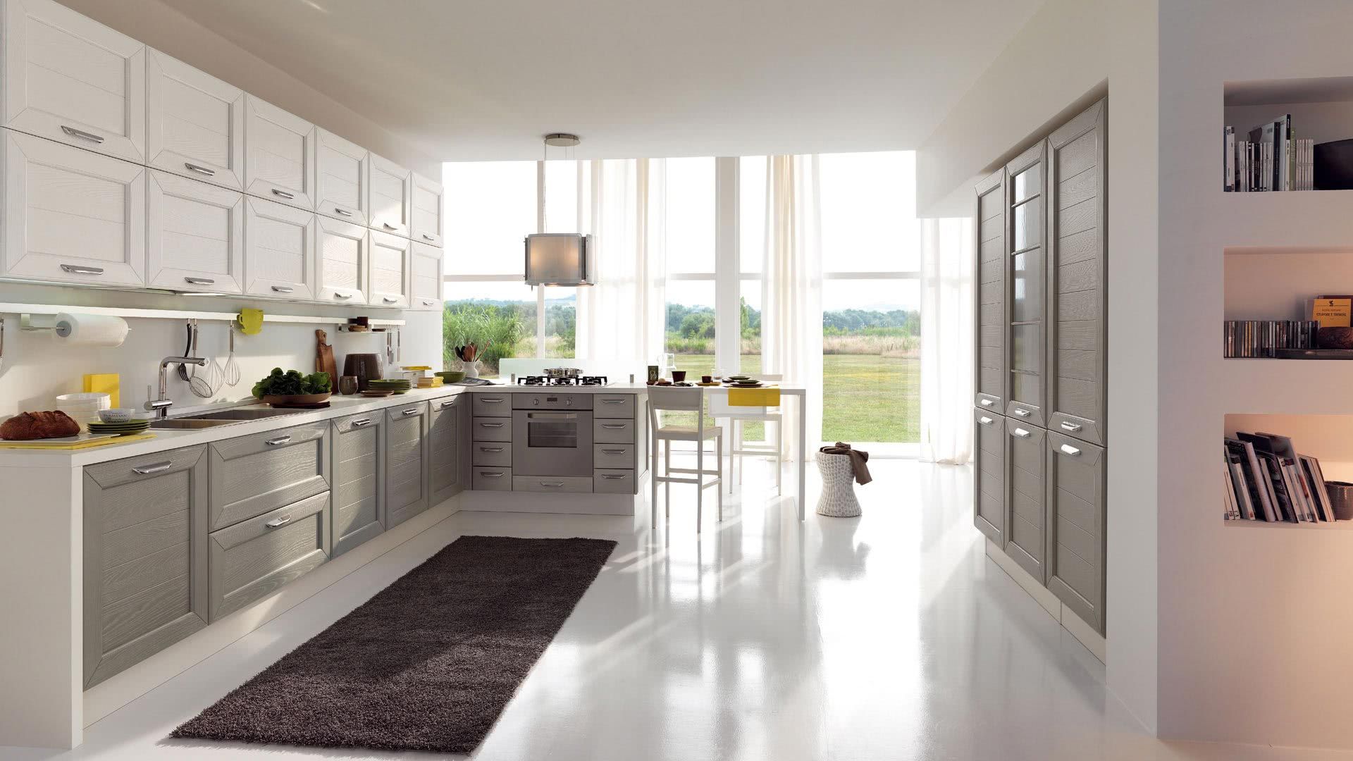 Una cucina con mobili bianchi e un tappeto sul pavimento
