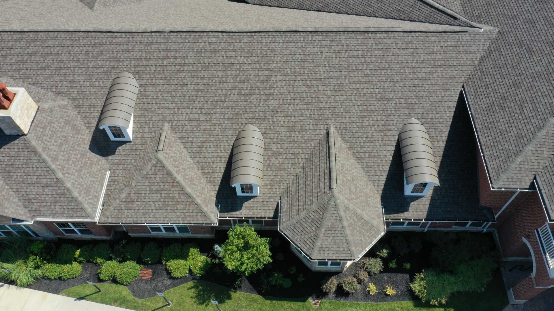 An aerial view of a large house with a gray roof.