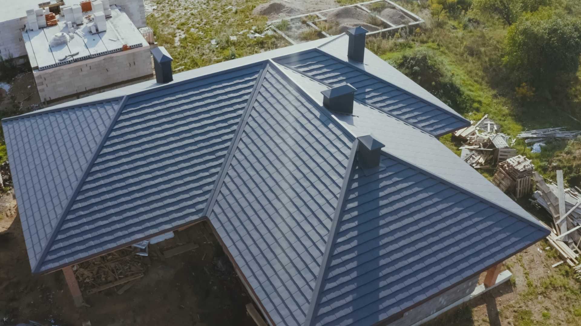An aerial view of a house under construction with a black roof.