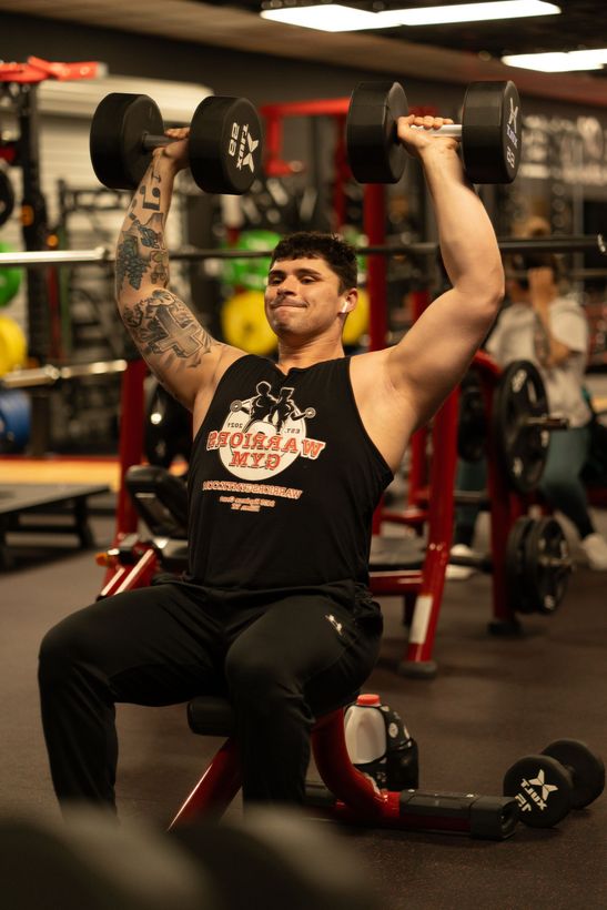Young active strong muscular sweaty man biceps muscle workout training