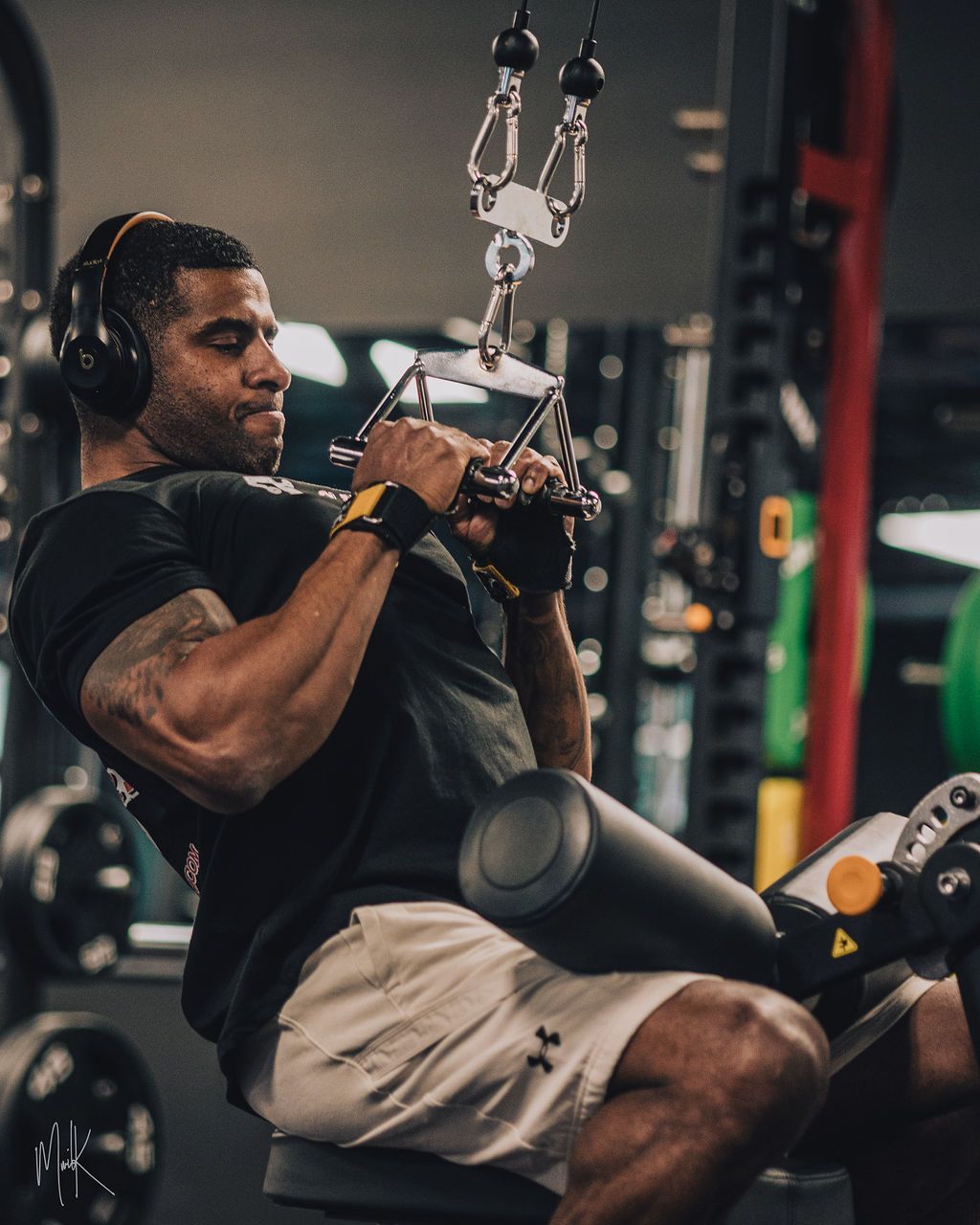A man wearing headphones is using a machine in a gym