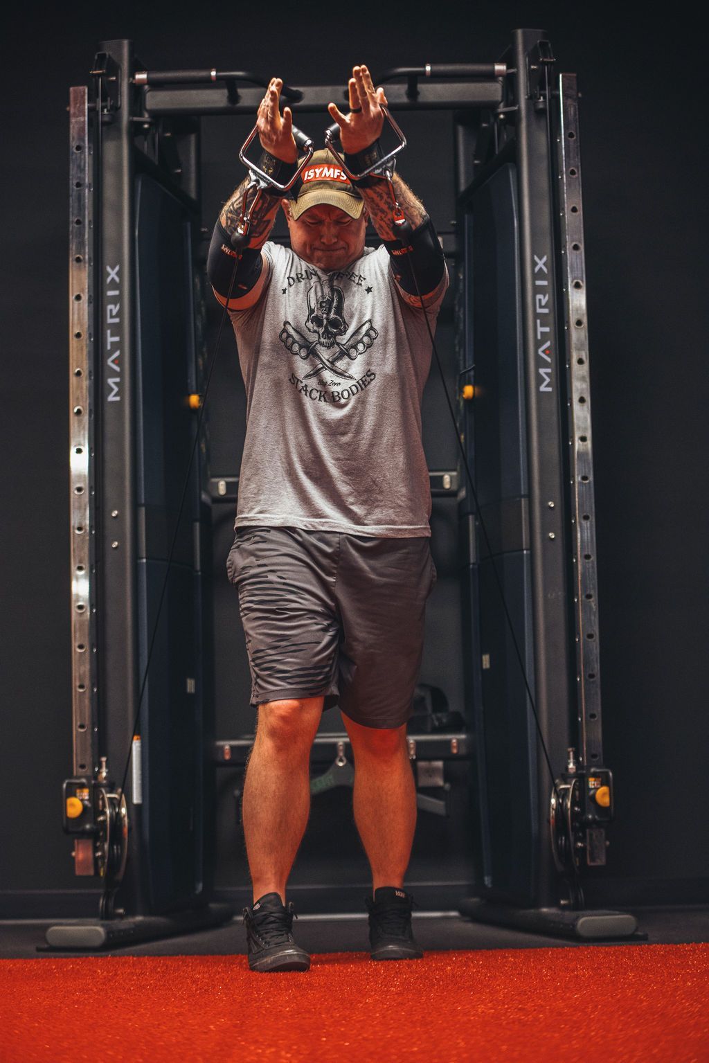A man is standing in front of a machine in a gym.