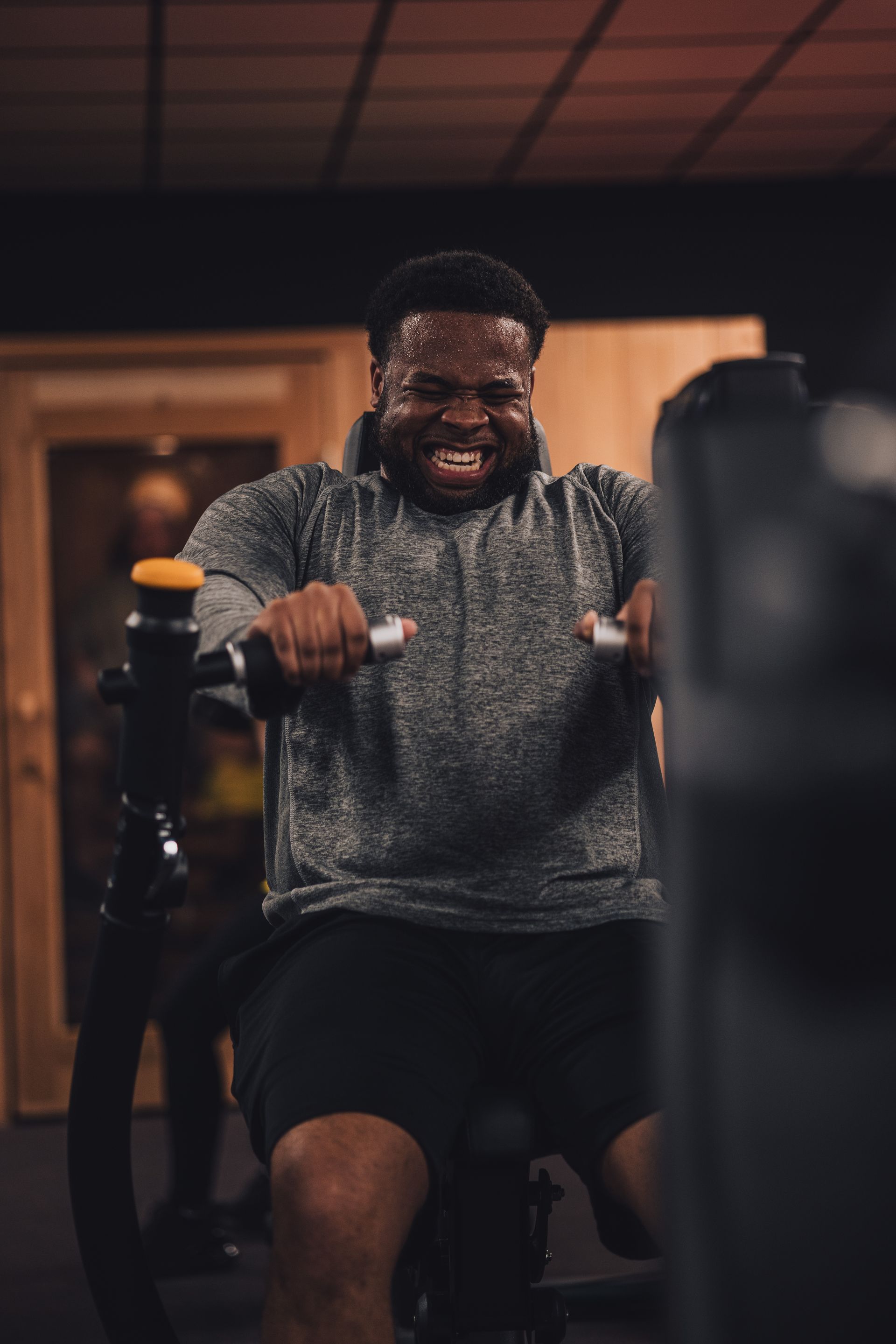 A man is riding an exercise bike in a gym.