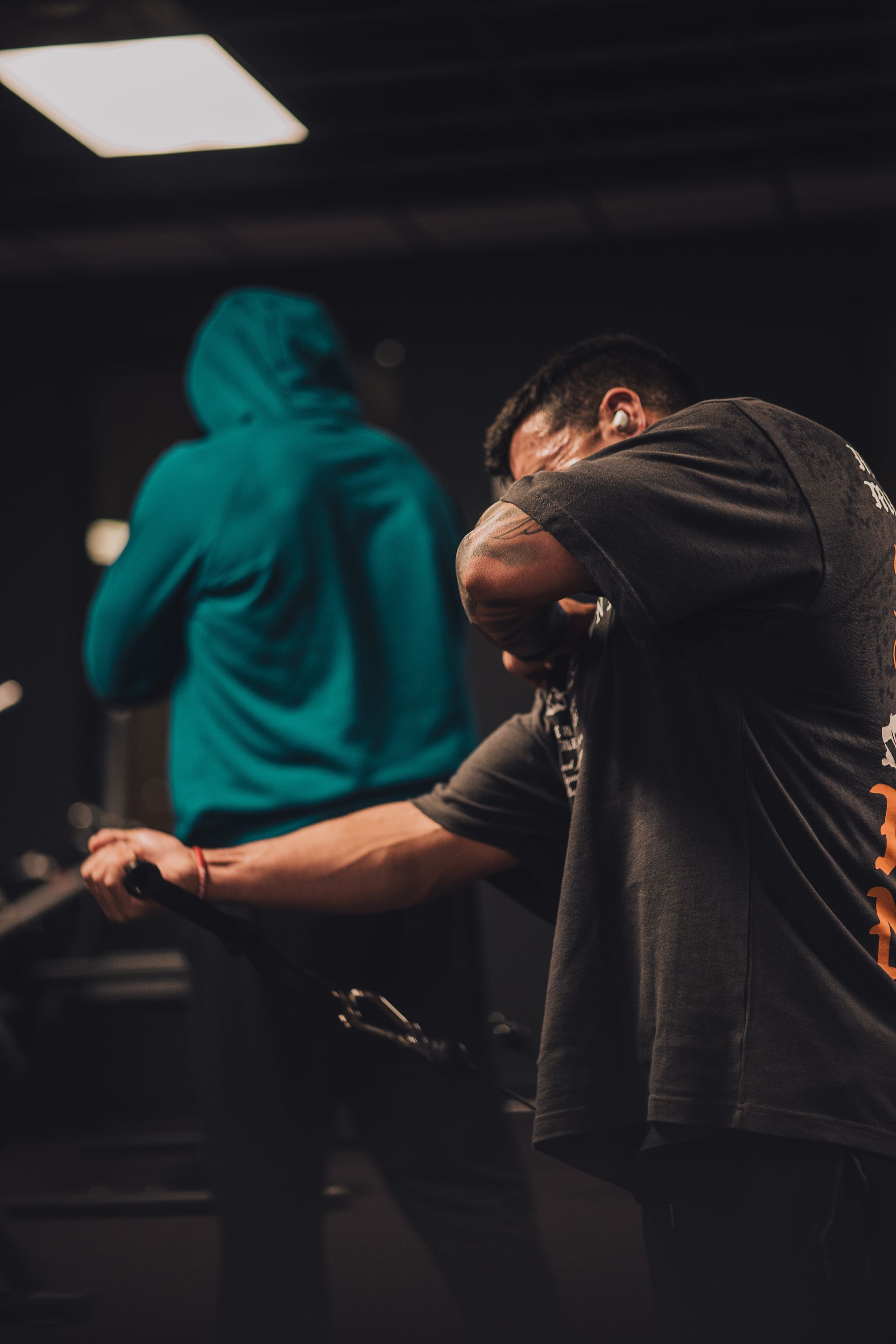 A man is standing in front of a microphone in a gym.