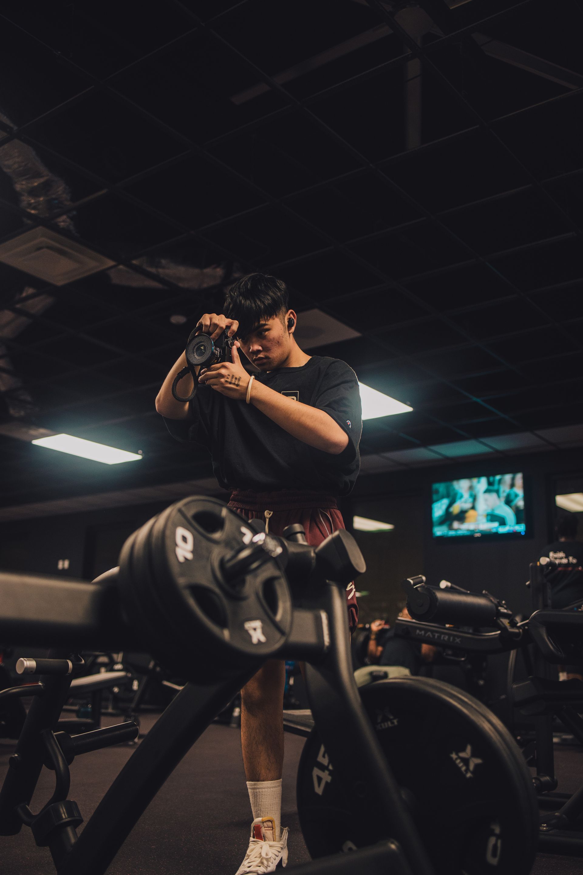 A man is taking a picture of himself in a gym.