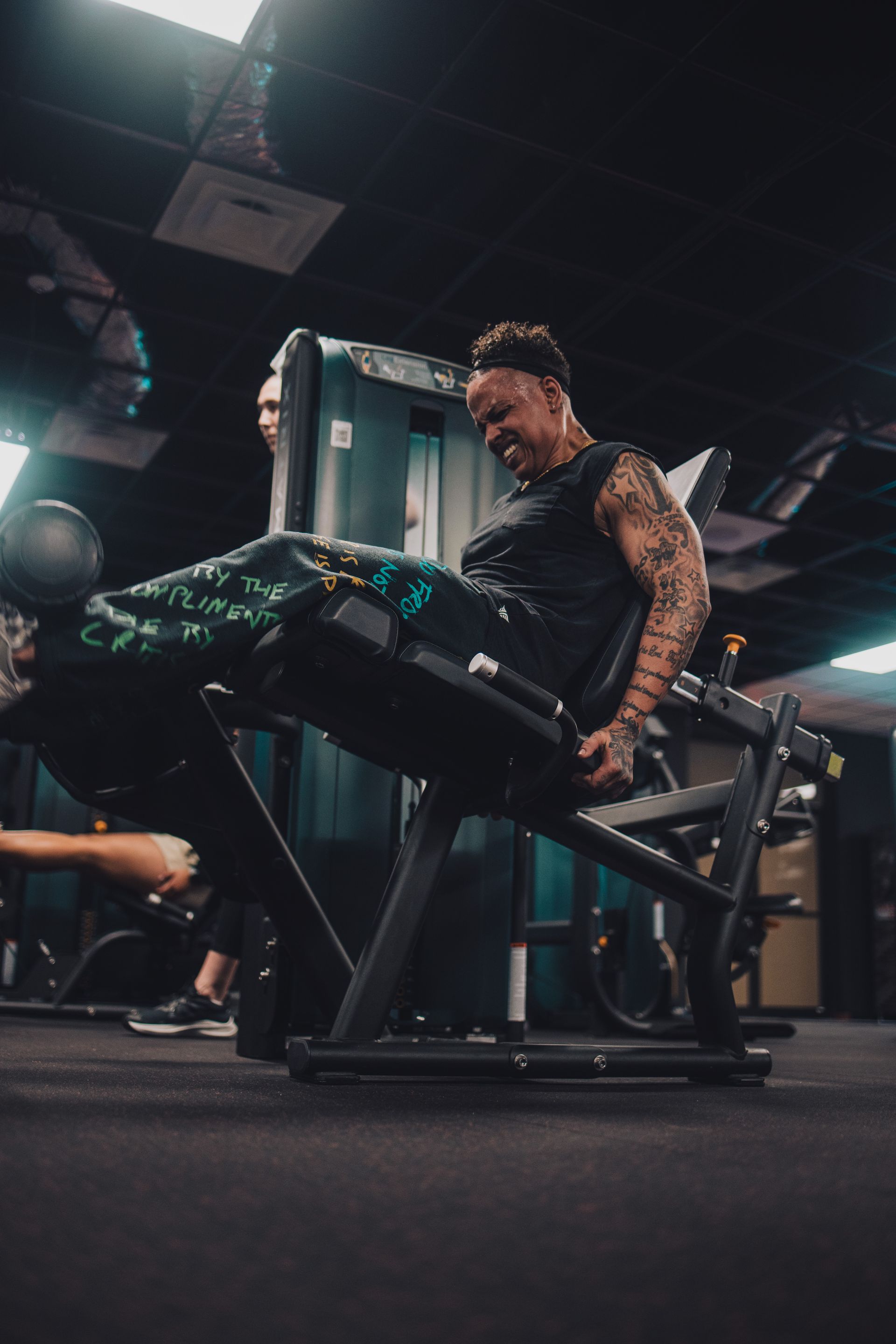 A man is sitting on a machine in a gym.
