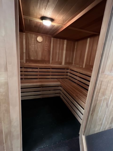 A wooden sauna with a clock on the wall
