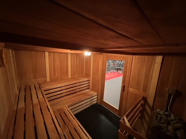 The inside of a wooden sauna with a glass door