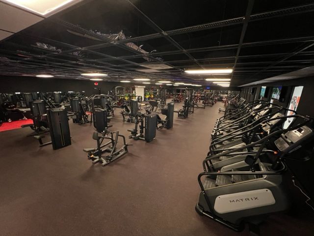A large gym filled with lots of exercise equipment.