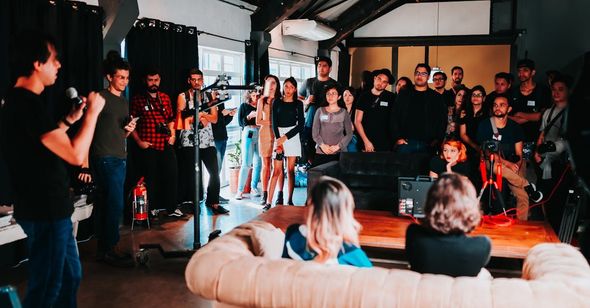 A group of people are sitting on a couch in front of a microphone.