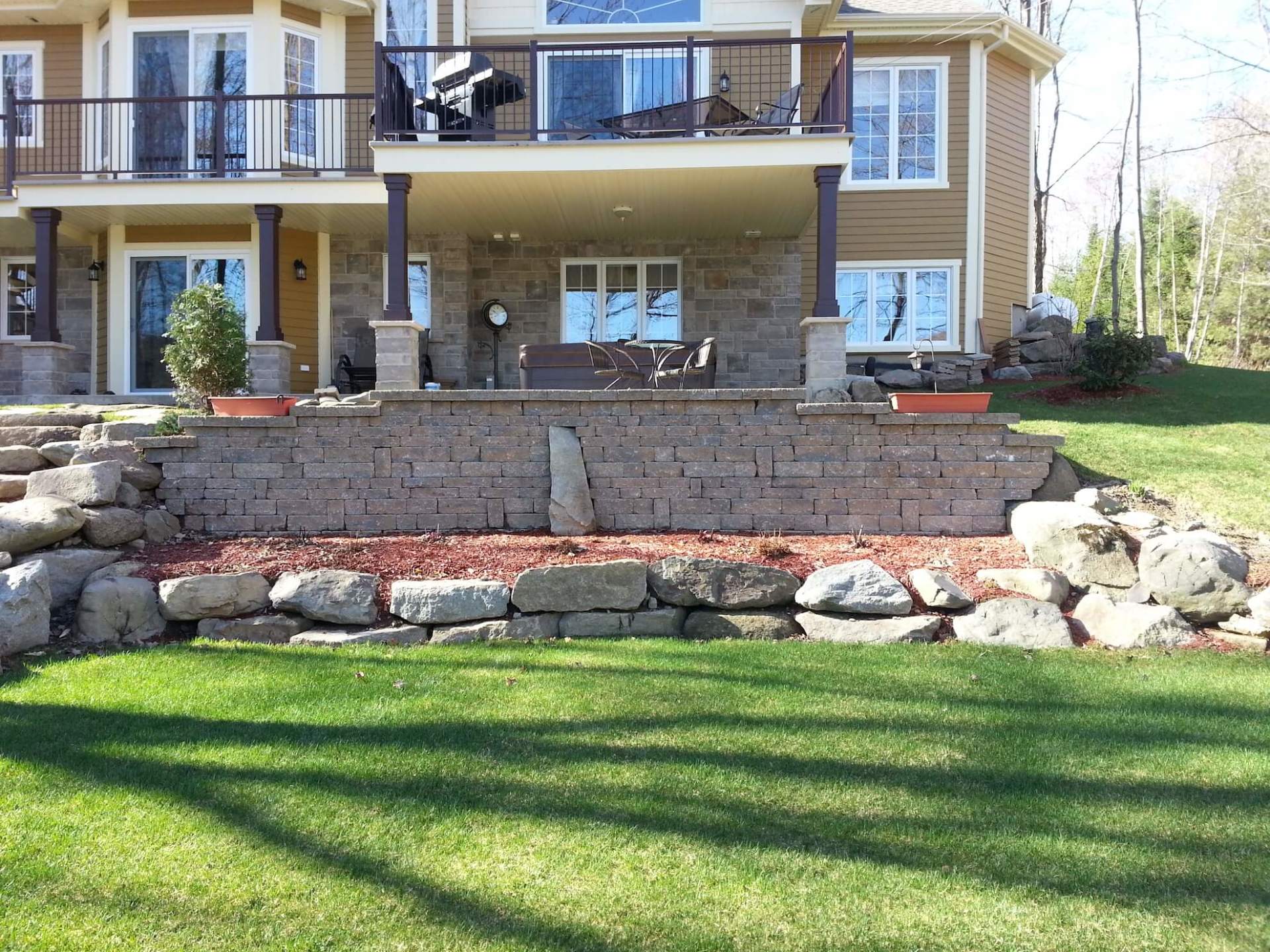Une grande maison avec un mur de briques devant