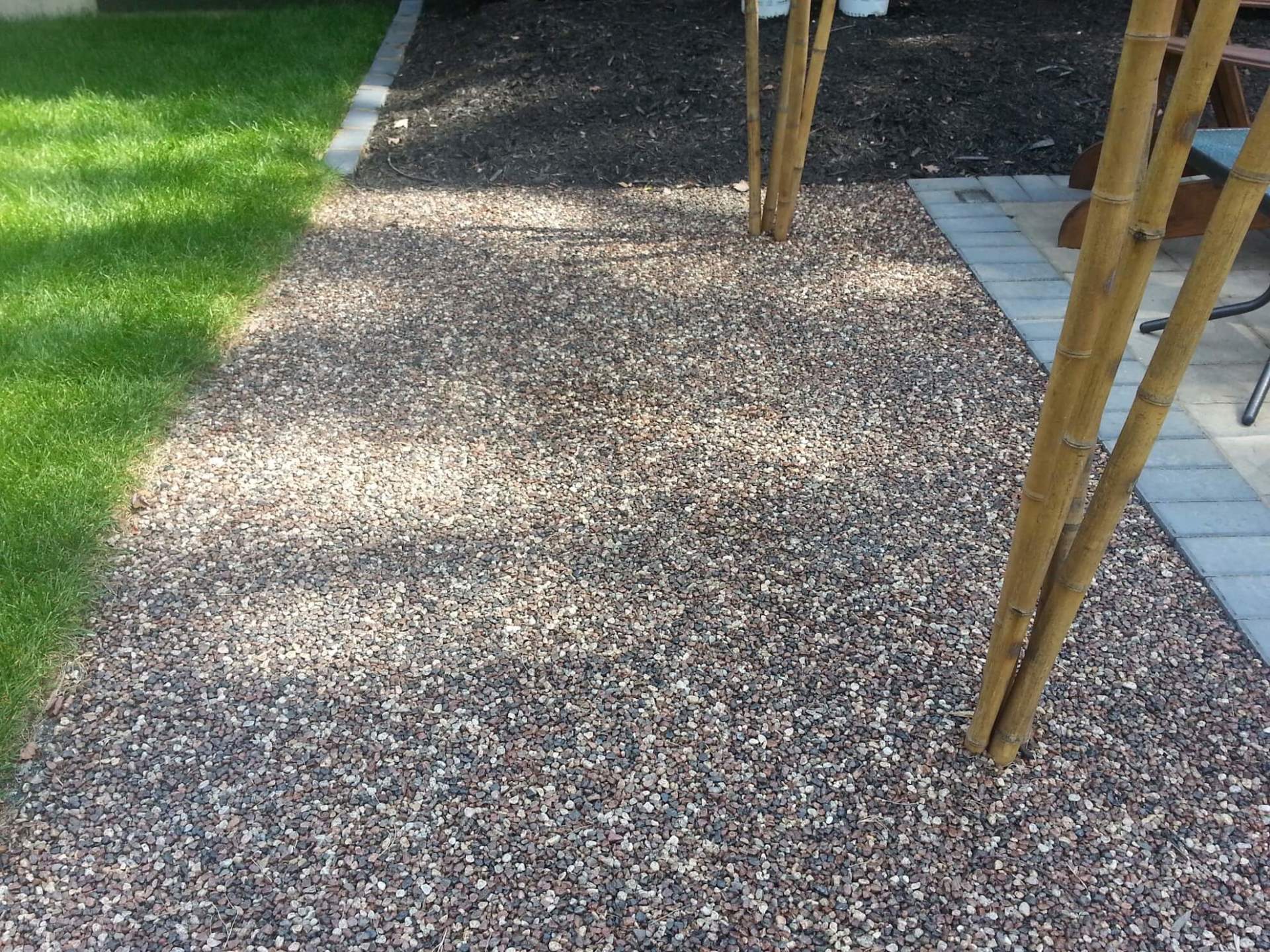 Une allée avec du gravier et de l'herbe en arrière-plan