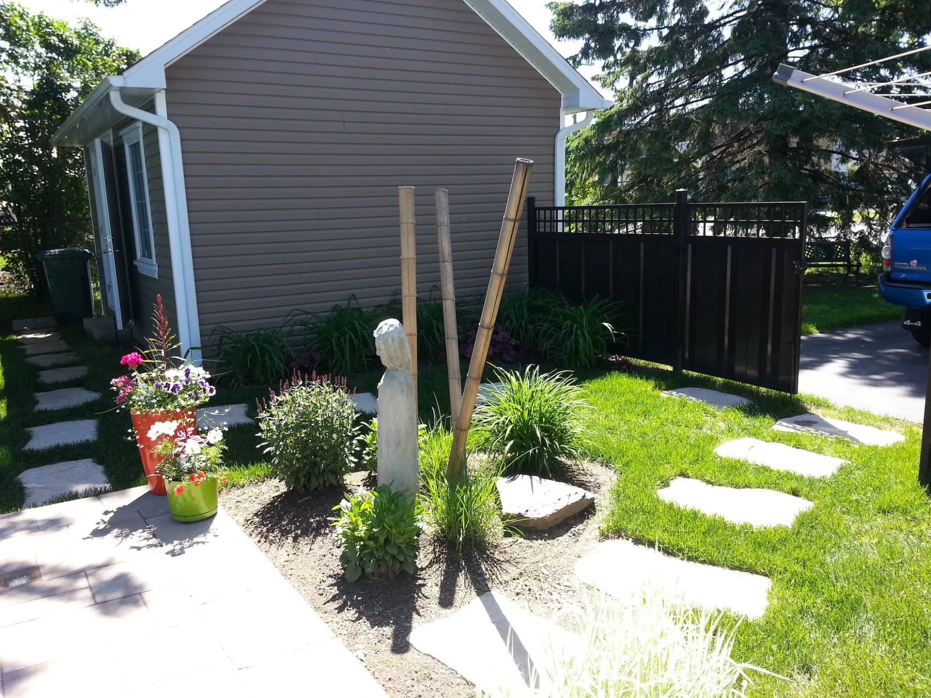 Une camionnette bleue est garée devant une maison