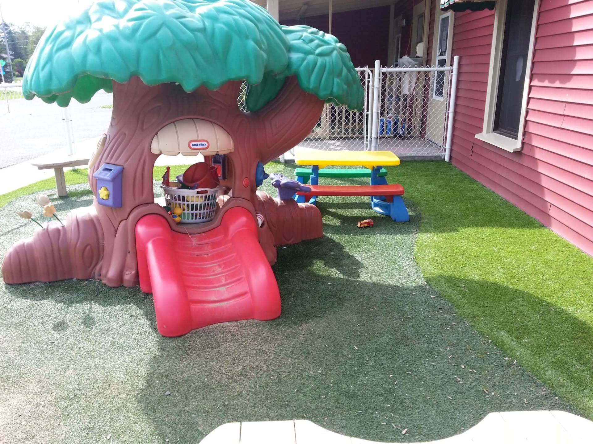 Une cabane dans les arbres avec un toboggan et une table de pique-nique