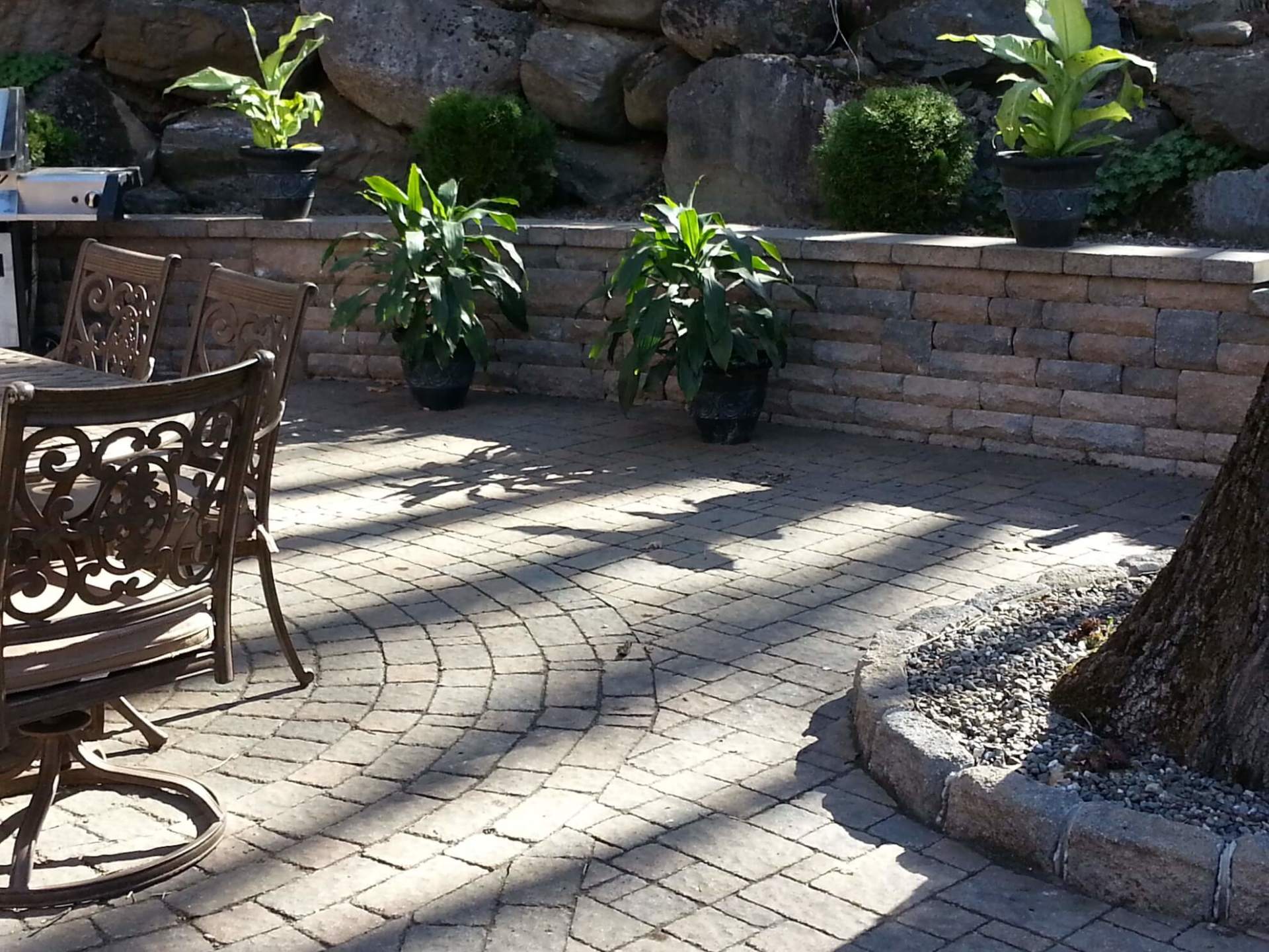 Un patio avec une table, des chaises et des plantes en pot