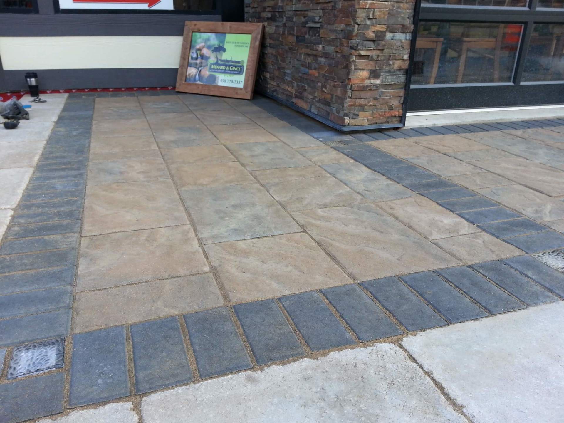 Une allée en briques avec une image dessus devant un bâtiment