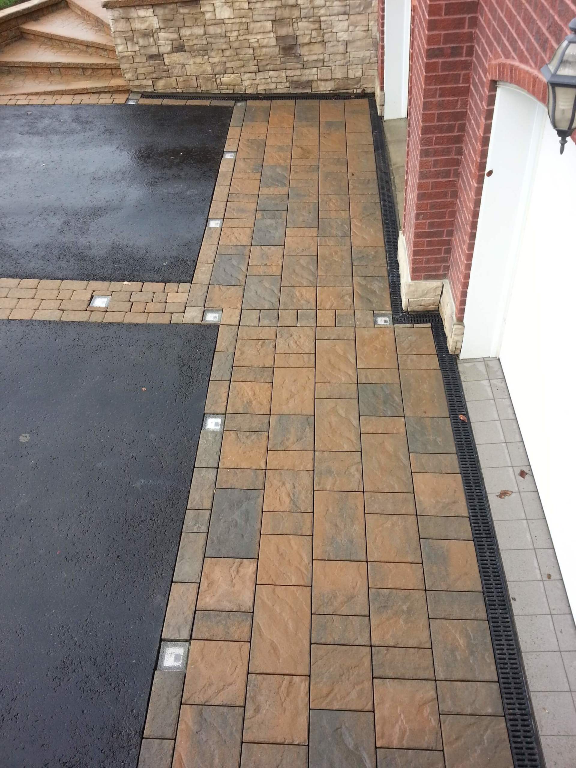 Une allée en briques menant à un garage à côté d'un bâtiment en briques