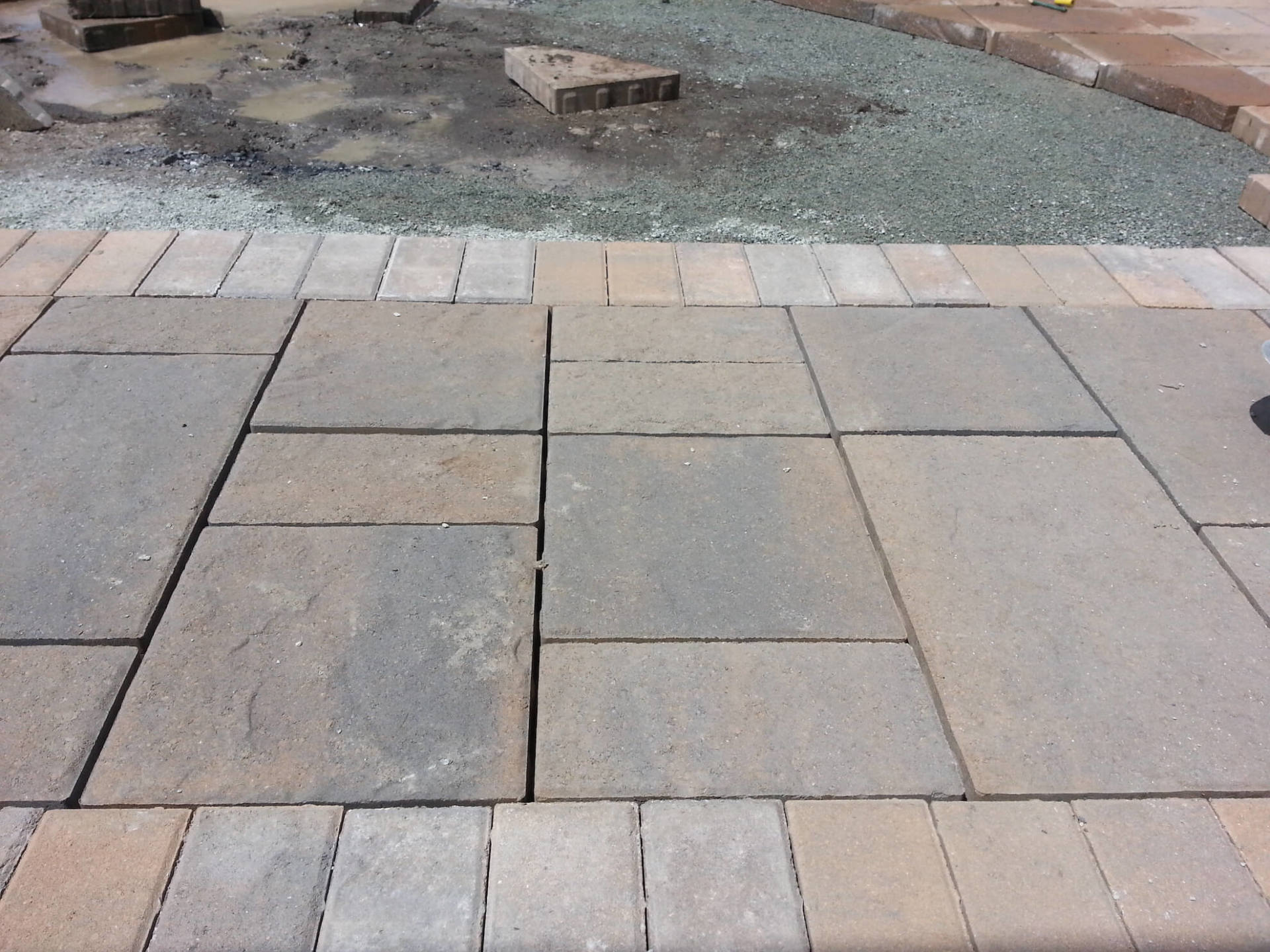 Une passerelle en briques est en cours de construction avec des briques et du gravier