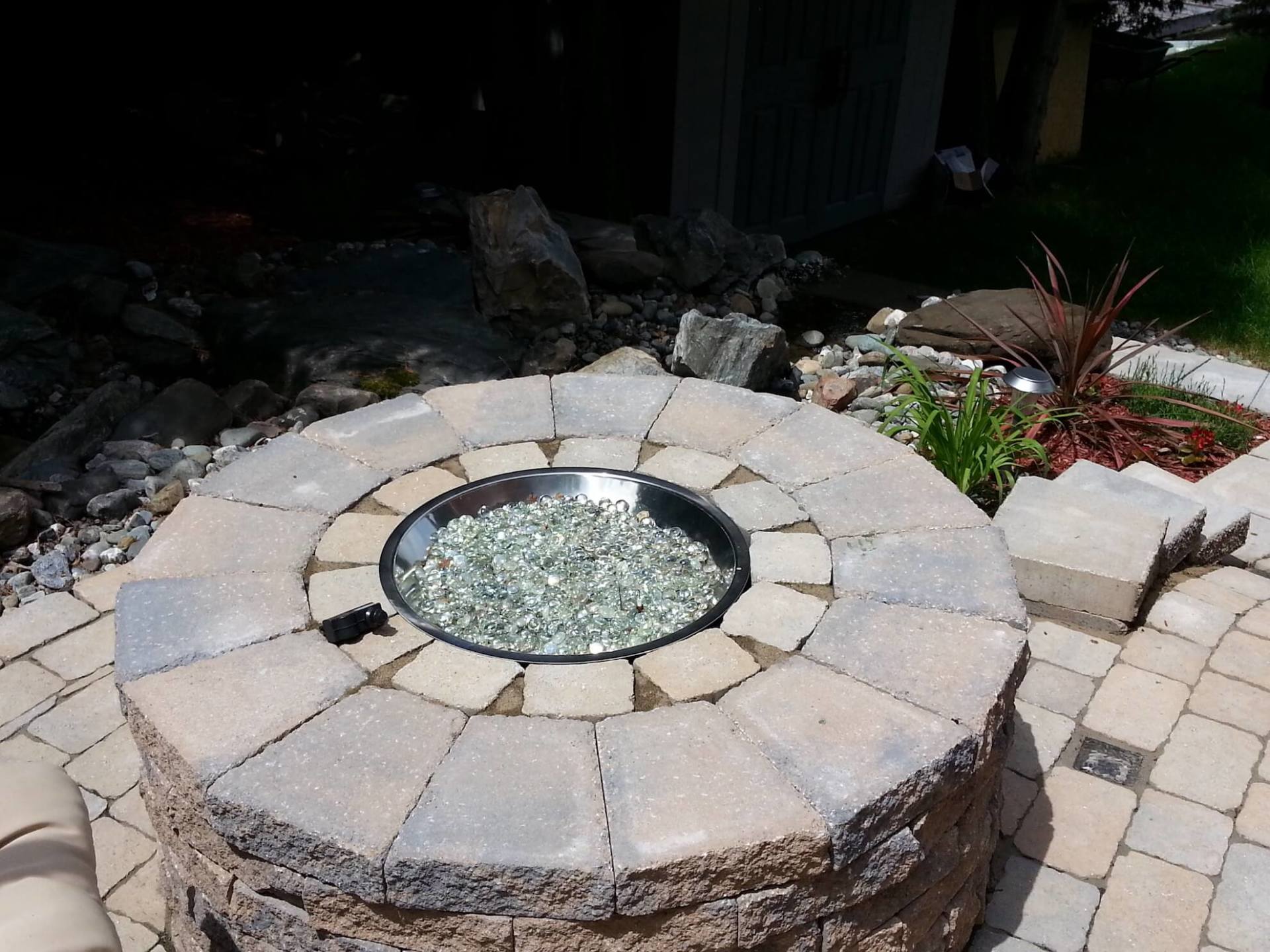 Un foyer entouré de briques et de rochers sur une terrasse