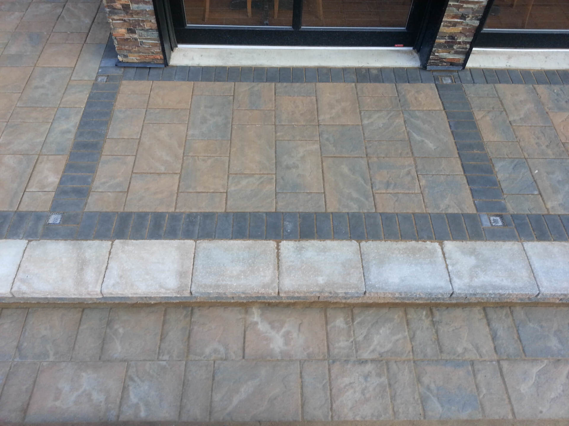 Une allée en briques avec des marches menant à une porte