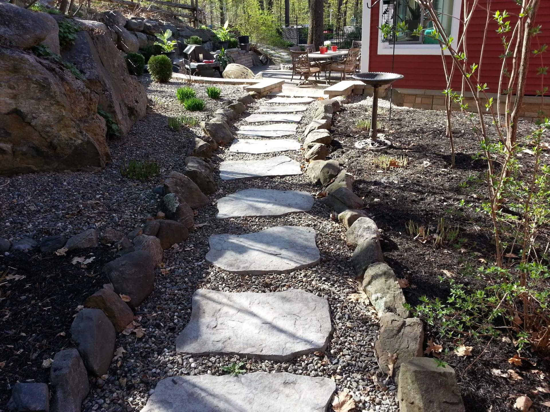 Une allée en pierre menant à une maison rouge