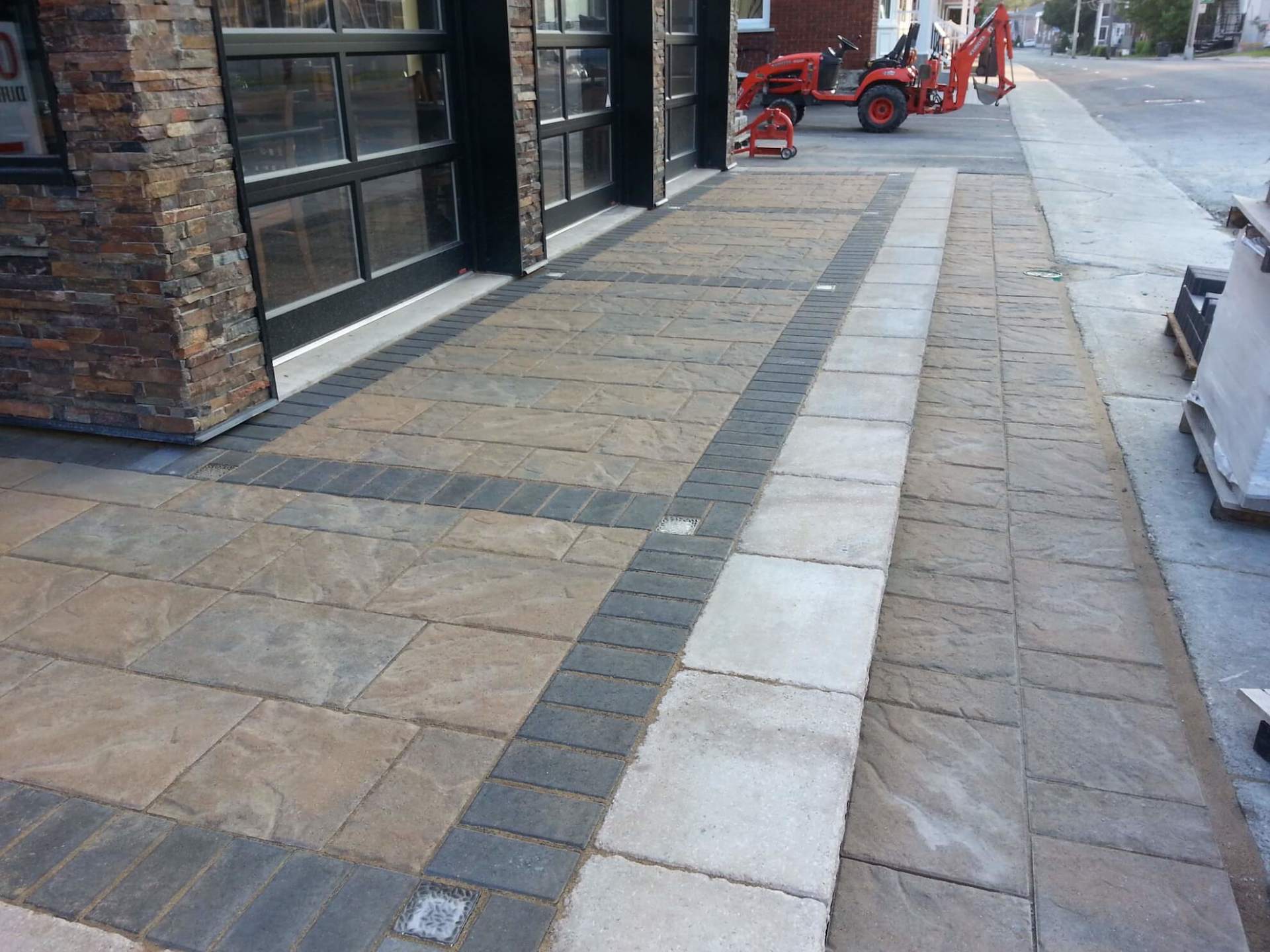 Une allée en briques avec un tracteur en arrière-plan