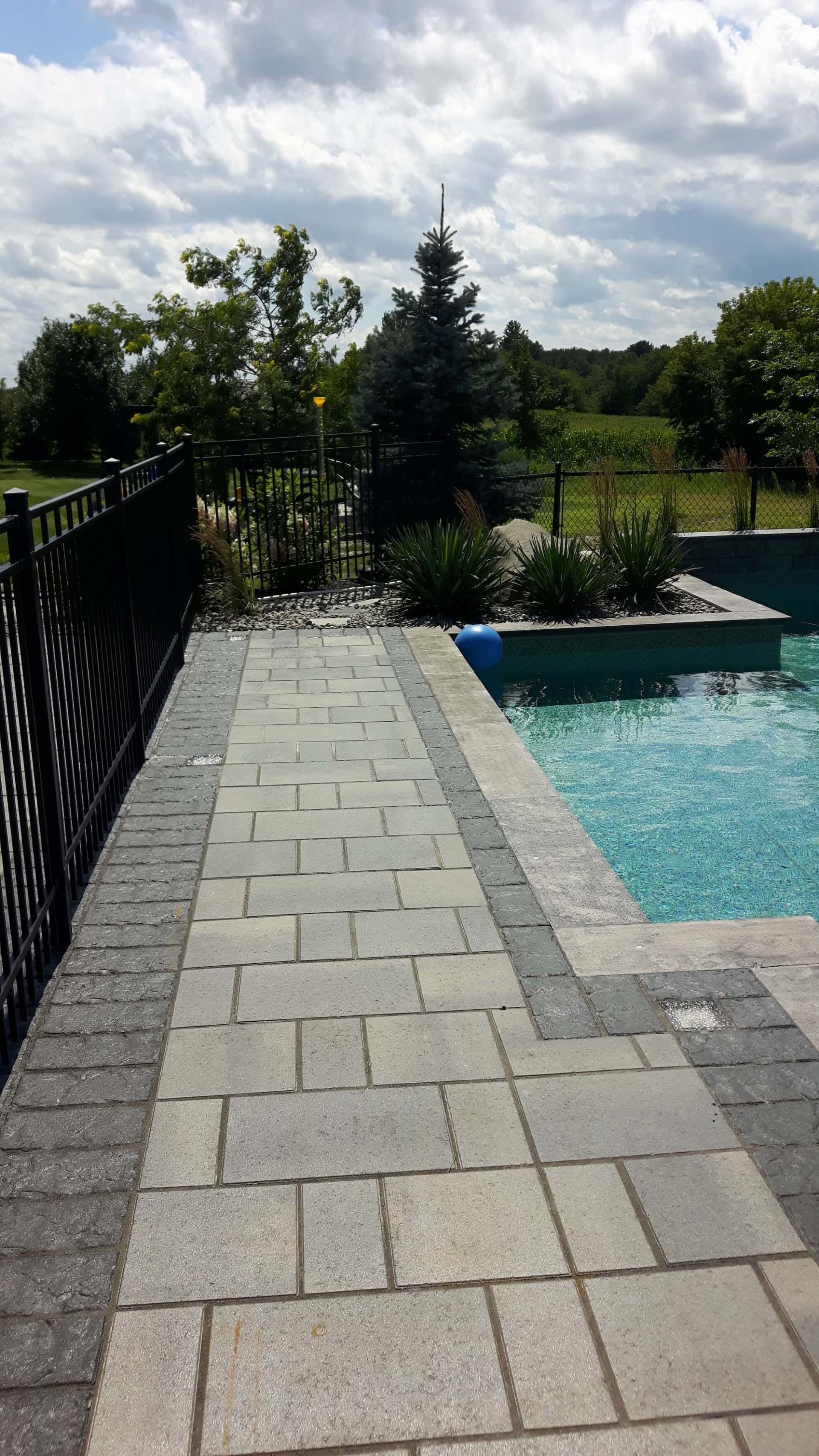 Une passerelle menant à une piscine avec une clôture en arrière-plan.