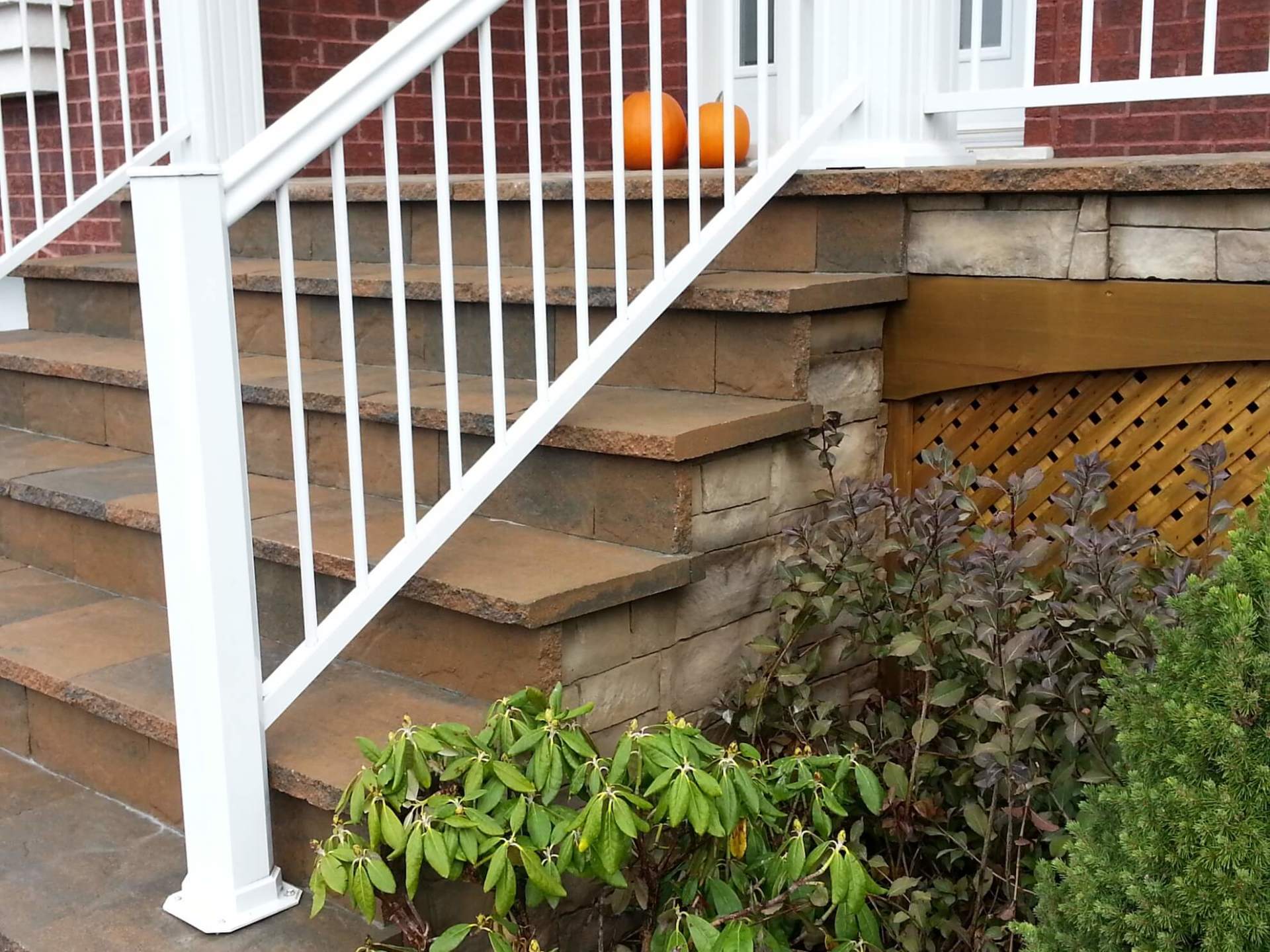 Une rampe blanche sur un escalier avec une citrouille au-dessus