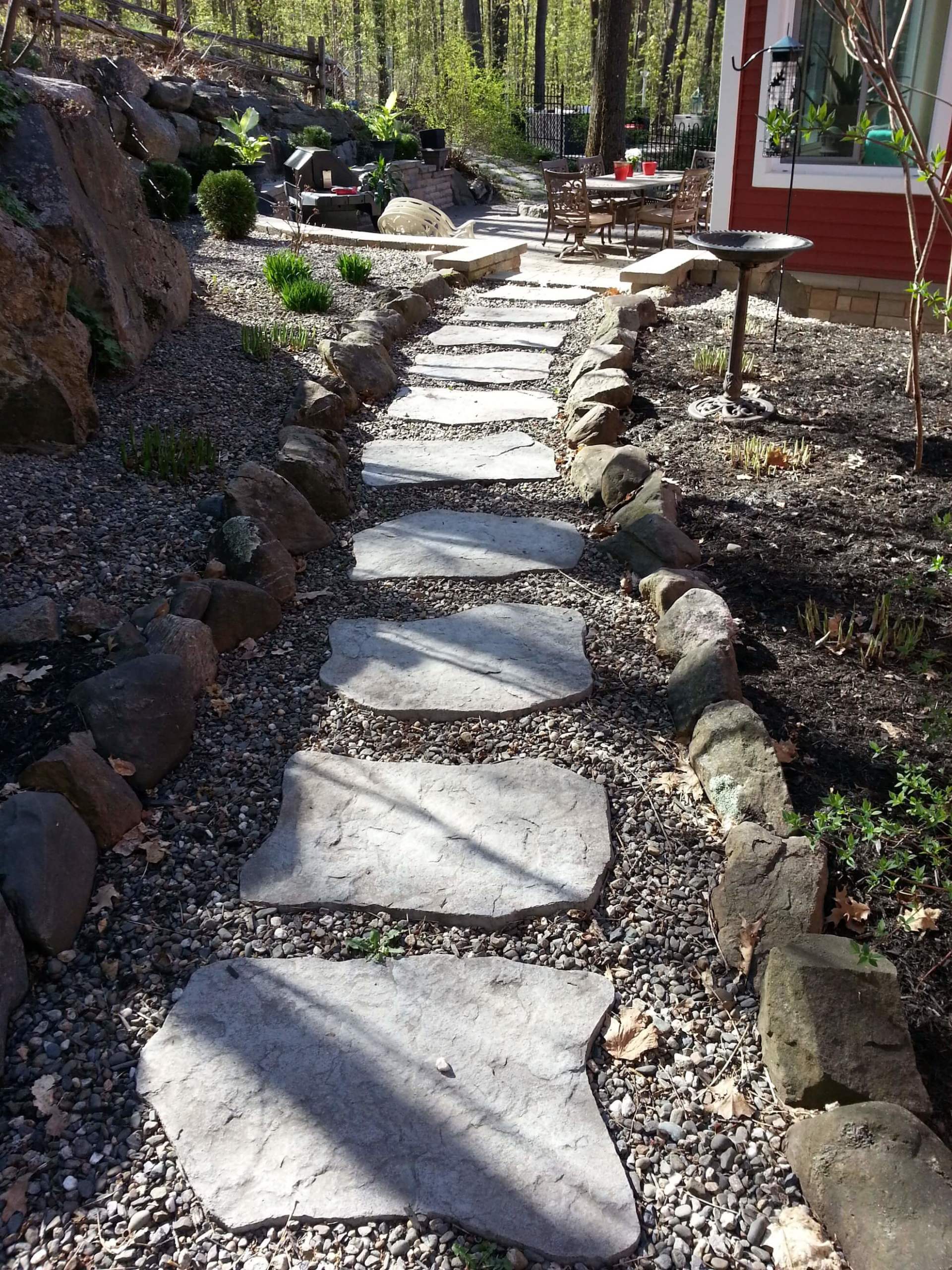 Un chemin de pierre menant à une maison dans les bois.