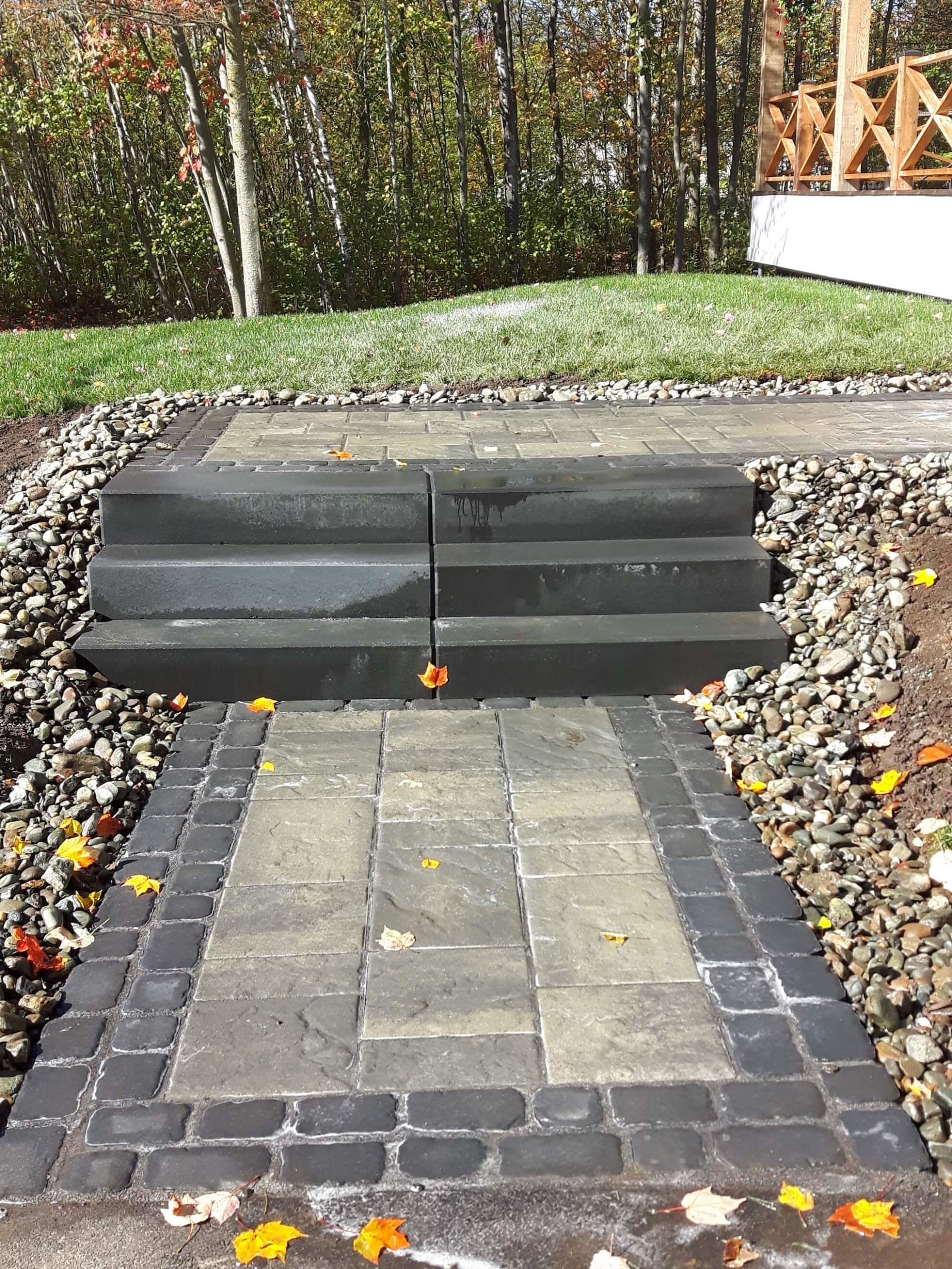 Une allée en pierre avec des escaliers menant à une terrasse.