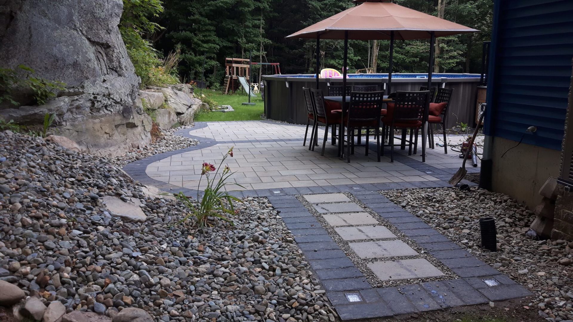 Un patio avec une table et des chaises sous un parasol