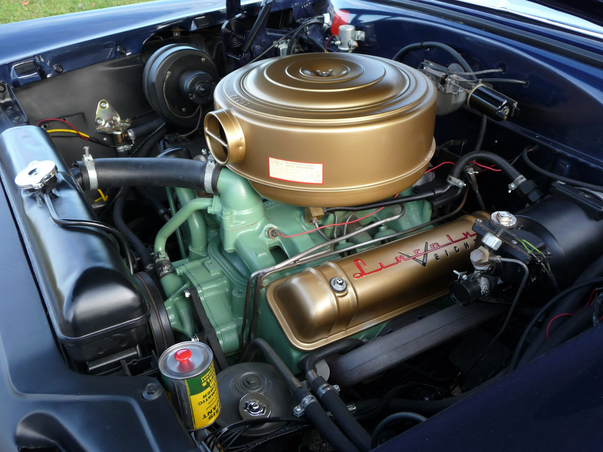 A close up of a car engine with a gold air filter