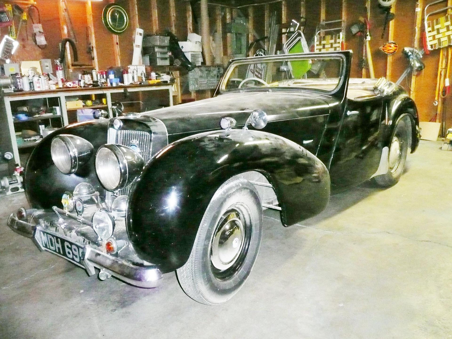 A black car is parked in a garage with a license plate that says oah 659