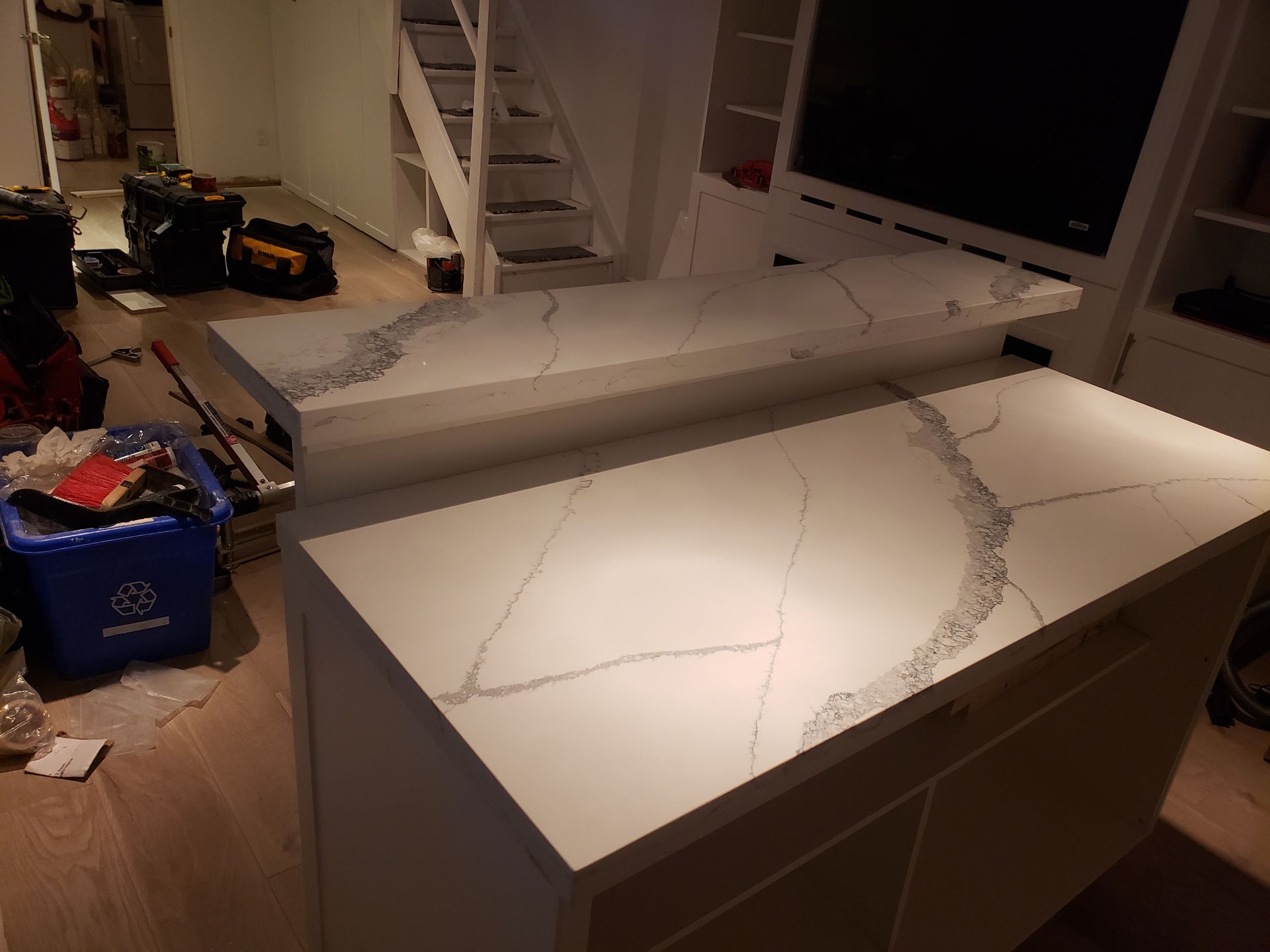 A kitchen island with a marble counter top in a living room.