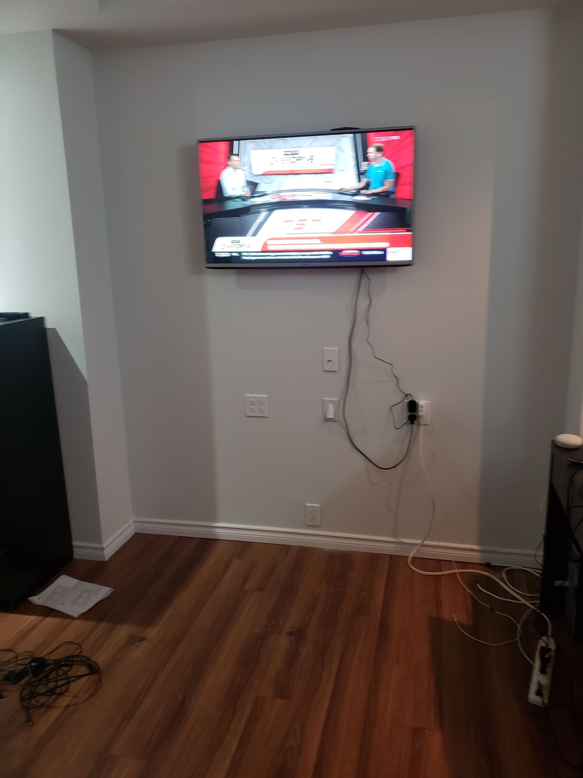 A flat screen tv is hanging on a wall in a living room.