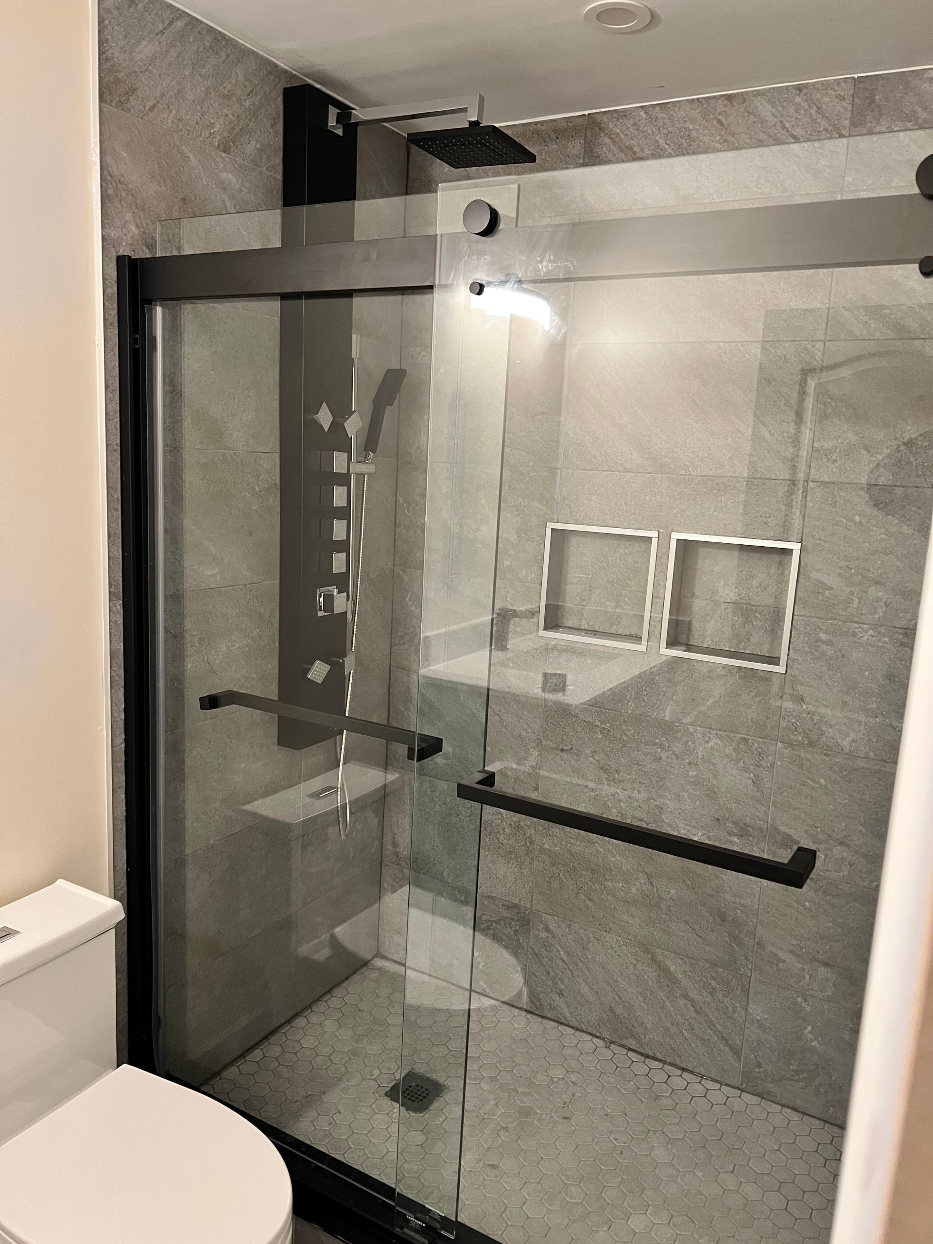 A bathroom with a sliding glass shower door and a toilet.