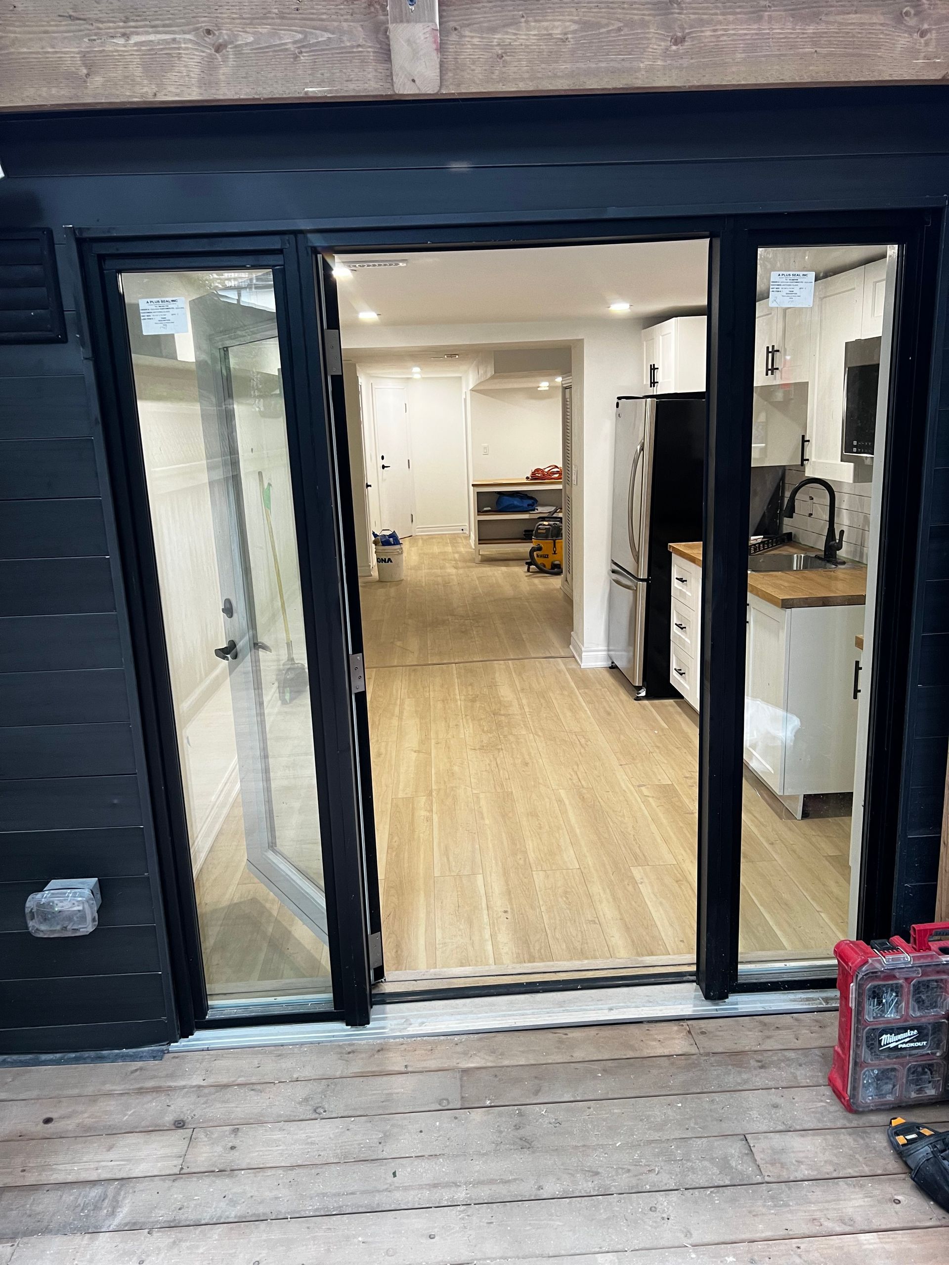 A sliding glass door is open to a kitchen.