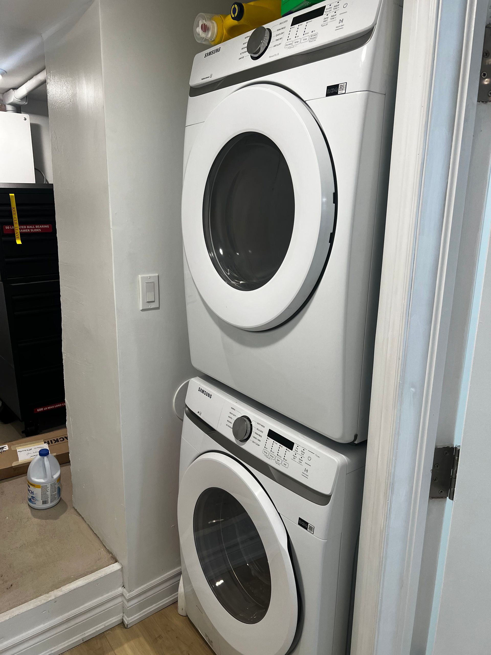 A washer and dryer are stacked on top of each other in a laundry room.