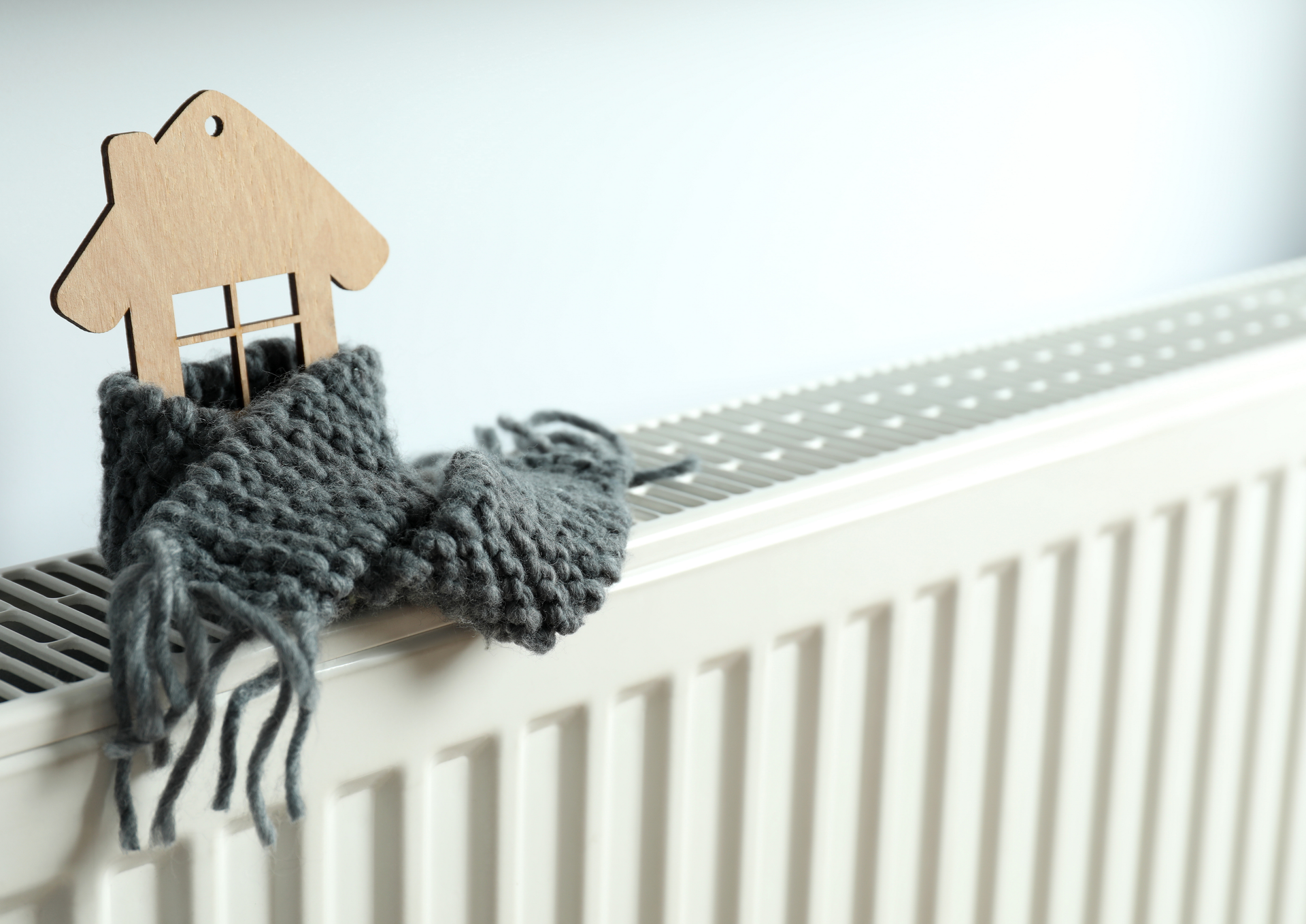 Two technicians in blue uniforms work on an HVAC unit near a large window.