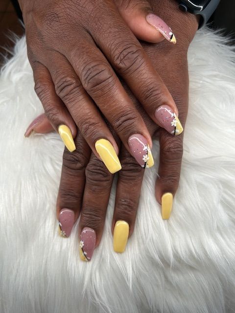 A close up of a woman 's nails with yellow and pink polish