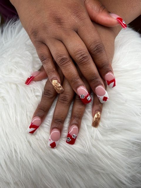 A close up of a woman 's nails with red and white designs