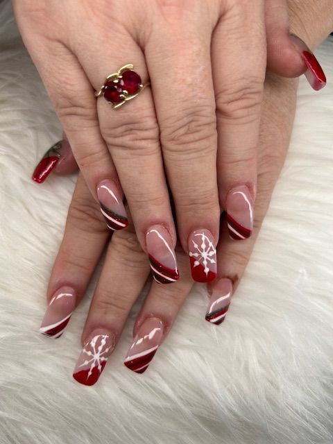 A close up of a woman 's nails with red and white designs