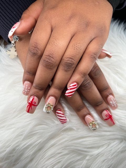 A close up of a person 's nails with a candy cane design.