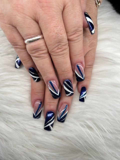 A close up of a woman 's hand with blue and white nails.
